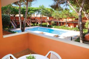 vistas a la piscina desde el balcón de un complejo en Villaggio Capistrano, en Bibione