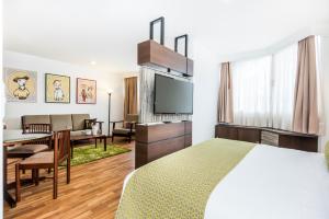 a hotel room with a bed and a living room at Hotel Vilar América in Bogotá