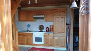 uma cozinha com armários de madeira e um forno com placa de fogão em Fewo to Hus em Bad Bederkesa