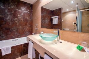 a bathroom with a bowl sink and a tub at Hotel Servigroup Montíboli in Villajoyosa