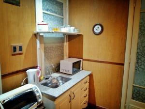 a small kitchen with a sink and a microwave at Apart céntrico (frente a plaza principal) in Zárate