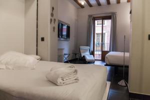 a hotel room with a bed with towels on it at Posada del León de Oro Boutique Hotel in Madrid