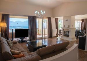 a large living room with a couch and a television at Villa Irida in Agios Nikolaos