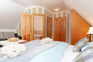 1 dormitorio con 1 cama con toallas en Vila Javorinka, en Tatranská Kotlina