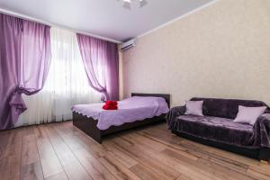 1 dormitorio con 1 cama y 1 sofá en Люкс на Гаражной почти в центре, en Krasnodar