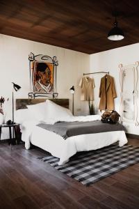 room00 Chueca Hostel في مدريد: غرفة نوم بسرير كبير ولوحة على الحائط