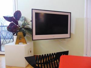 a flat screen tv hanging on a wall at Thissio View Design Apartment in Athens