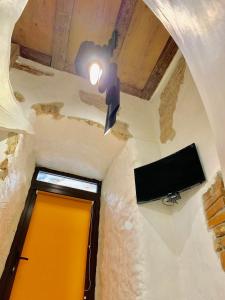 un corridoio con porta gialla e TV di Апартаменти з сауною на Площі Ринок для 4 -х гостей - в еко стилі a Lviv