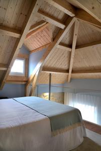 duże łóżko w pokoju z drewnianymi sufitami w obiekcie Mayor's Apartments w Porto