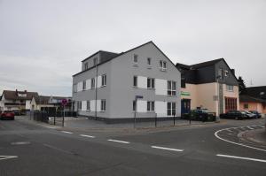 ein weißes Gebäude an der Straßenseite in der Unterkunft Ebersheim Luxus Plaza in Mainz