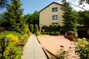 a house and a garden with a brick walkway at Villa Ambra in Osowa