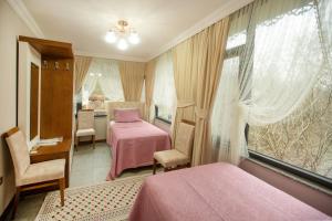 ein Schlafzimmer mit einem rosa Bett und einem Fenster in der Unterkunft Jolnar garden hotel in Macka + 66 Fotos