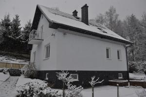 ein weißes Haus mit Schnee drauf in der Unterkunft Apartmány CENTRUM in Rajecké Teplice