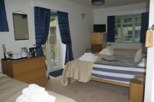 a hotel room with two beds and a mirror at Woodacre B & B in Arundel