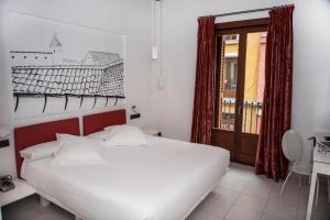 a bedroom with a white bed and a window at Posada del León de Oro Boutique Hotel in Madrid