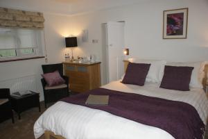 a bedroom with a large bed with a book on it at Woodacre B & B in Arundel