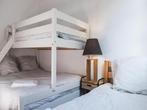a bedroom with two bunk beds and a lamp at Family Travel Paris 2 in Bussy-Saint-Georges
