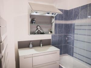 een badkamer met een wastafel en een spiegel bij Family Travel Paris 2 in Bussy-Saint-Georges +7 foto's