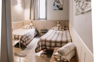 a small room with two beds and a window at Pensión 45 in Barcelona