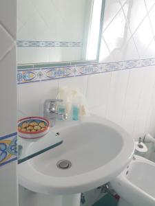 a white bathroom with a sink and a mirror at Villa Casola B&B in Positano +30 photos