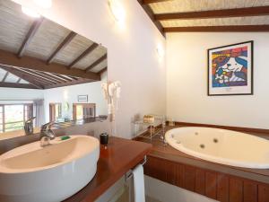 a bathroom with a large tub and a sink at Pousada Perequê in Ilhabela