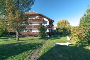 a large house in a park with a bench in the grass at Sonnen Residence in Collalbo