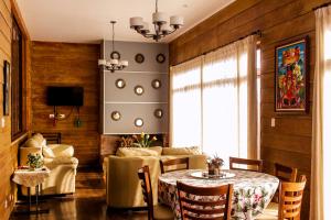 a living room with a table and a couch at Espectacular casa de montaña con jacuzzi, chimenea a leña y BBQ in Zarcero