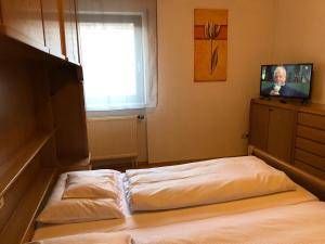 a room with two beds and a tv and a window at Landhotel Gasthof Zur Krone in Leidersbach