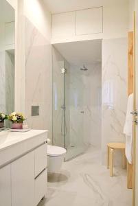 a white bathroom with a shower and a toilet at Mayor's Apartments in Porto