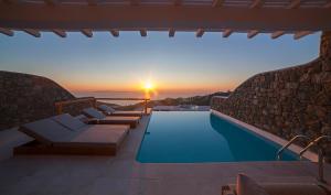 a villa with a swimming pool and a sunset at VILLA APOLLO-PRIVATE POOL-AMAZING VIEW in Mýkonos City
