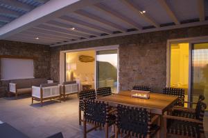 a dining room with a wooden table and chairs at VILLA APOLLO-PRIVATE POOL-AMAZING VIEW in Mýkonos City