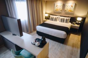 a hotel room with a bed and a desk at GrandView Hotel Buenos Aires in Buenos Aires