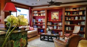 a living room with book shelves filled with books at Hôtel La Marisa Grande Plage in Saint-Jean-de-Luz