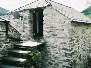 an old stone building with a window and stairs at Plasglasgwm in Betws-y-coed