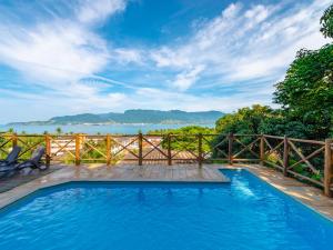 a swimming pool with a view of the water at Pousada Perequê in Ilhabela