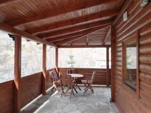 eine abgeschirmte Veranda mit einem Tisch und Stühlen darauf in der Unterkunft Vikendice Biocinovici in Kolašin