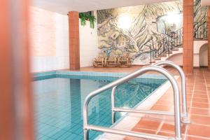 a swimming pool with a handrail in front of a mural at Sonnen Residence in Collalbo