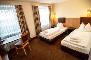 um quarto de hotel com duas camas e uma cadeira em Ausbildungshotel St. Theresia em Munique
