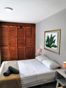 a bedroom with a large bed with wooden cabinets at Apartment & Studio 28 in Playa del Carmen