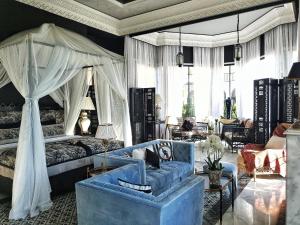 ein Schlafzimmer mit einem blauen Sofa und einem Himmelbett in der Unterkunft Palais Ronsard Relais & Chateaux in Marrakesch