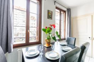 d'une salle à manger avec une table, des chaises et une fenêtre. dans l'établissement Appartements Paola, Pamela, Patricia et Pascale, à Strasbourg