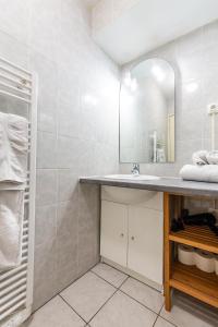 a bathroom with a sink and a mirror at Appartements Paola, Pamela, Patricia et Pascale in Strasbourg