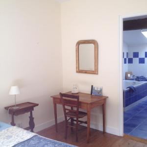 - une chambre avec une table, un miroir et un lit dans l'établissement B&B Château Pierre de Lune, à Saint-Émilion