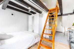 a bedroom with a ladder next to a bed at Appartements Paola, Pamela, Patricia et Pascale in Strasbourg