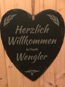 a heart shaped sign hanging on a wooden wall at Ferienwohnung Hubertus in Bischofsmais