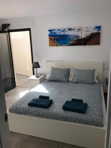 a bedroom with a bed with two blue pillows on it at casa sea front costa teguise in Costa Teguise