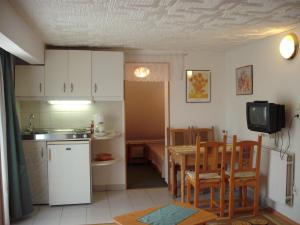 a kitchen and dining room with a table and a television at Apart Hévízi Ház in Hévíz