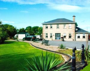 a large house with cars parked in the driveway at Kingstown House in Cashel