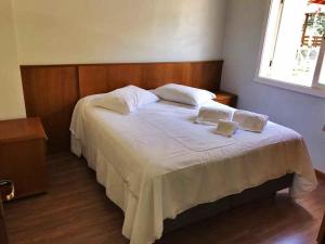 ein Schlafzimmer mit einem Bett mit zwei Kissen darauf in der Unterkunft Sobrados Muller in Gramado