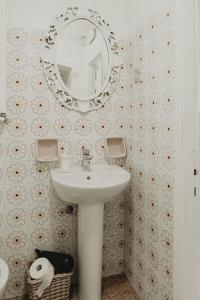 a bathroom with a sink and a mirror on the wall at “Ivory house”with sea view in Manarola +9 photos